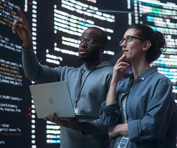 two people looking at banks of computers