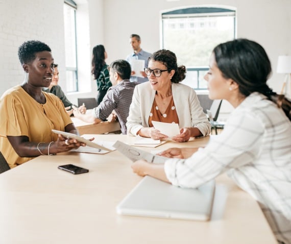 three women meeting over a table in office