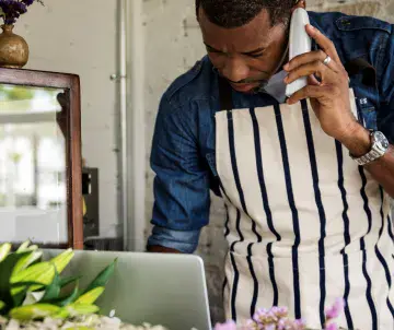 man with apron on phone