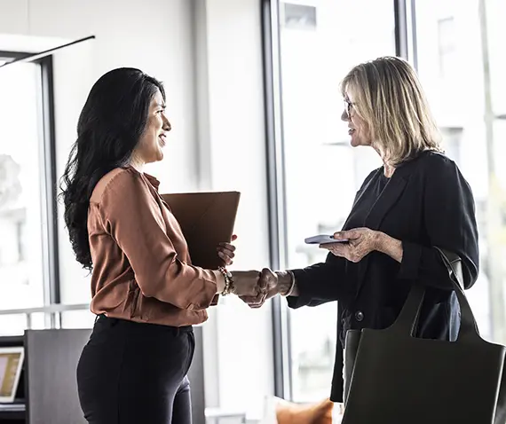 two women at work shaking hands